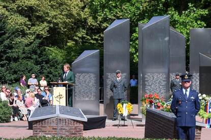 De staatssecretaris spreekt voor het monument.