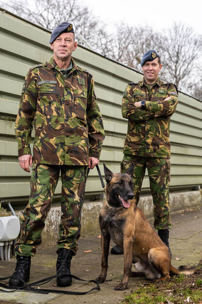 Portret van majoor Egon van Kessel en adjudant Jan Willem Jonk met een hond.