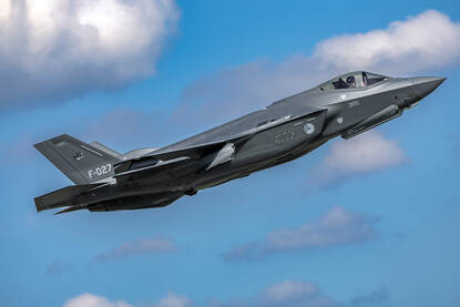 Links een vliegende Nederlandse F-35, rechts een Poolse F-16.