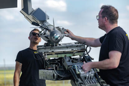 Links: Onderhoudspersoneel werkt aan een F-35 die voor een shelter staat. Rechts: Bewapeningspersoneel is bezig met de controle van een Sidewinder-luchtdoelraket.