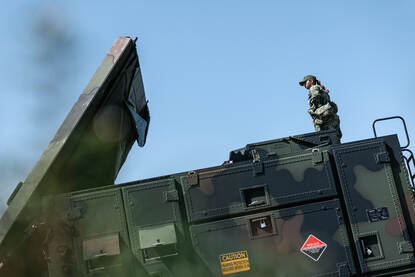 Een vrouwelijk militair volgt het omhoogkomen van de Patriot-radar.