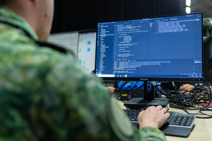 Foto van een computer met daarop een softwarecode.