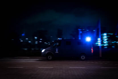 Bus van de KMar die met blauw zwaailicht vooruit rijdt.