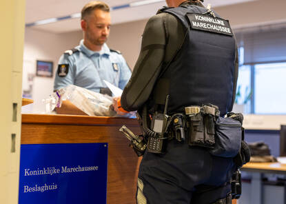 Een marechaussee komt goederen afgeven bij het Keten Beslaghuis
