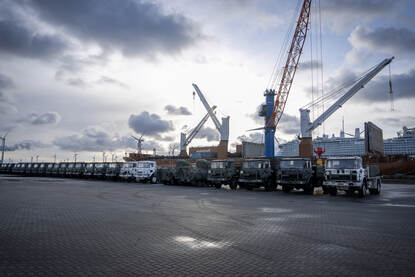 Een lange rij naast elkaar geparkeerde viertonners op de kade in de Eemshaven.