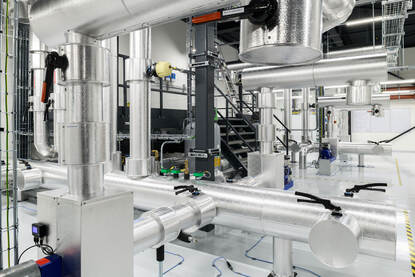 Technische ruimte met aluminiumkleurige installaties voor koeling.