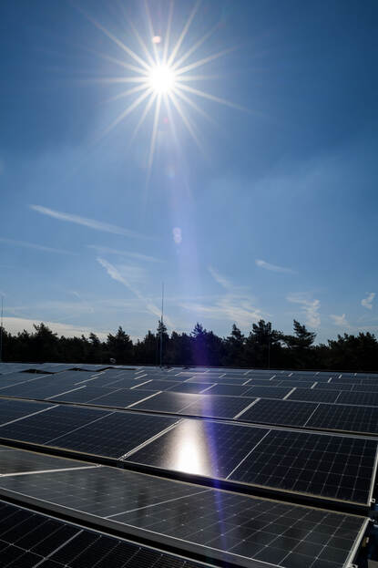 Zonnepanelen met een schijnende zon erboven.