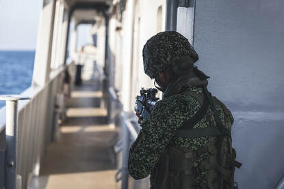 Colombiaanse mariniers klimmen aan boord van het schip en lopen met getrokken wapen over de dekken.